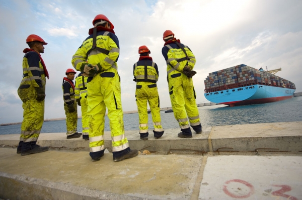 estibadores en el puerto esperando buque de contenedores